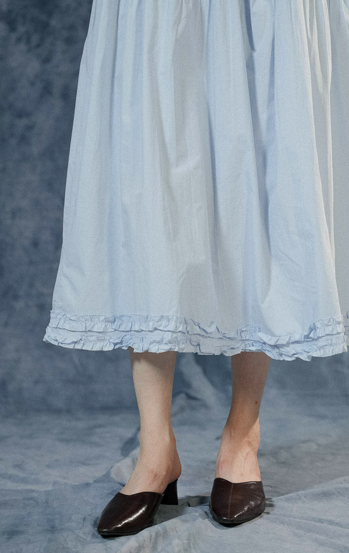 Rok panjang (maxi skirt) wanita Lacey warna biru berbahan katun dengan detail tingkat (tiered), jahitan bergelombang di tengah, aksen ruffle bawah, dan pinggang karet.