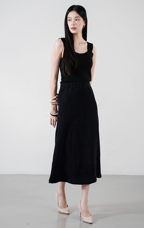 Adara Skirt warna indigo, rok midi lurus berbahan brushed twill dengan atasan hitam.