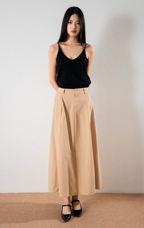 Almira Skirt Khaki, rok panjang katun warna khaki dengan detail lipit depan, dipadukan dengan atasan hitam dan sepatu hak tinggi hitam