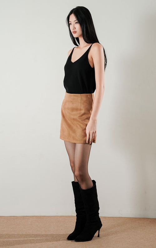 Anders Skort Brown, rok celana mini berpotongan rapi berbahan suede warna cokelat, dipadukan dengan atasan hitam dan stoking tipis.