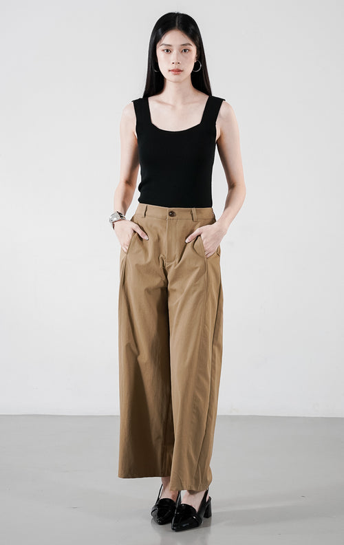 Emmanuel Pants warna khaki, celana panjang kulot berpotongan lebar (wide-leg) dengan siluet minimalis, dipadukan dengan tank top hitam.