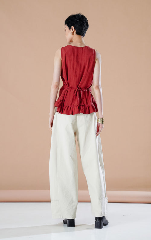 Atasan wanita Odellia Top warna Terracotta dengan detail peplum rampel, kancing depan aktif, dan tali samping yang dapat disesuaikan untuk gaya kasual elegan