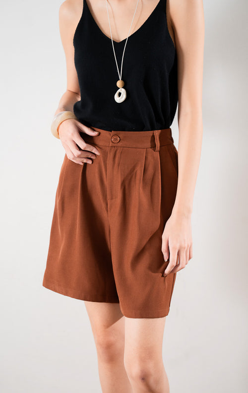 Oliver Pants warna Terracotta dengan kancing depan, resleting, dan lipatan rapi (pleats) untuk tampilan formal casual