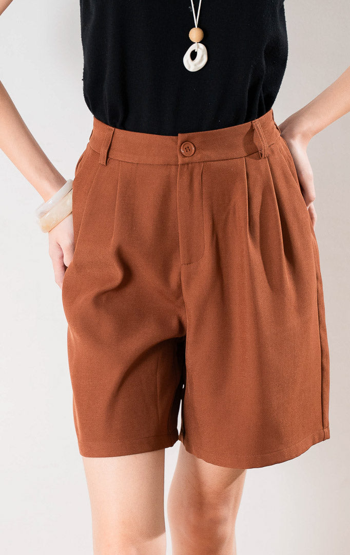 Oliver Pants warna Terracotta dengan kancing depan, resleting, dan lipatan rapi (pleats) untuk tampilan formal casual