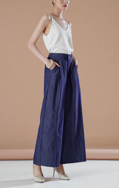 Celana panjang wanita Paulina Pants Dark Denim berbahan chambray lembut dengan siluet wide leg, detail lipatan depan, dan kancing resleting