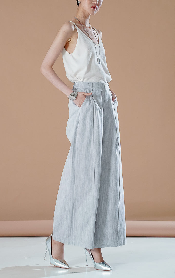 Celana panjang wanita Paulina Pants warna Light Grey berbahan chambray lembut dengan potongan kaki lebar (wide leg) dan detail kancing depan.