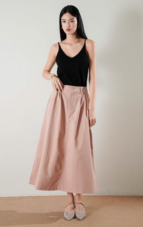 Rafaela Skirt Dusty Pink, rok panjang A line dengan detail lipit (pleats) di bagian depan, dipadukan dengan atasan hitam dan sepatu flat glitter.