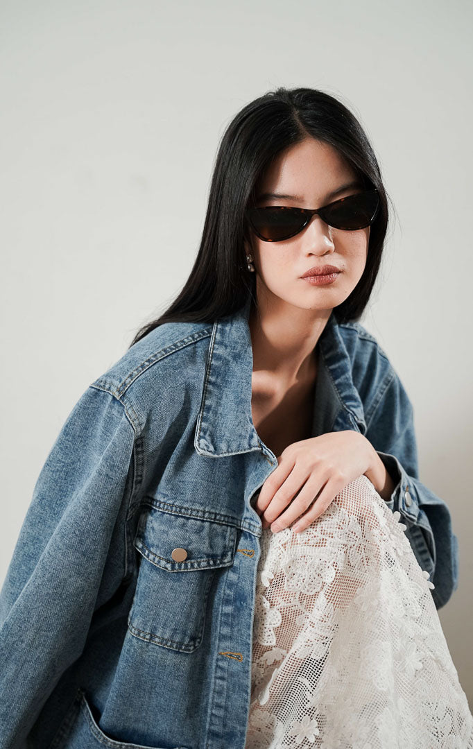 Sara Jacket Denim, jaket jeans biru dengan empat saku depan besar, dipadukan dengan rok bordir putih Safiya Skirt.