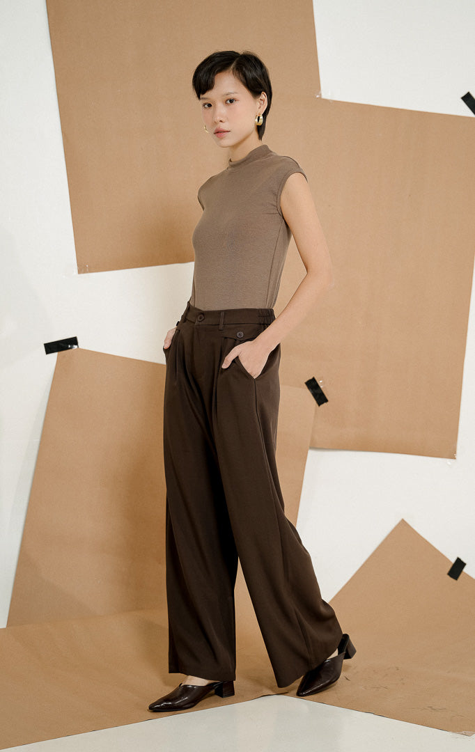 Model mengenakan Adelie Classic Straight Pants Dark Brown, celana panjang kerja wanita dengan potongan lurus elegan dipadukan dengan atasan cokelat.