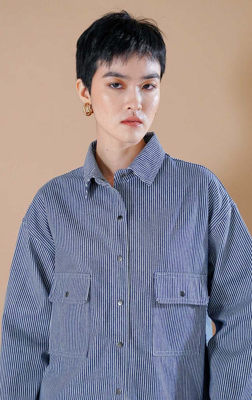 Adriana Shirt kemeja button up bermotif garis dark denim dengan dua saku depan, dipadukan dengan celana jeans berpotongan longgar