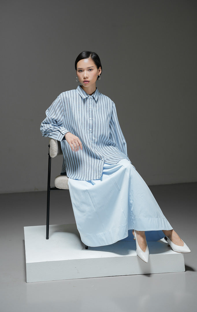 Kemeja wanita Adrienne Top warna biru dengan motif garis salur vertikal (stripe), lengan panjang, kerah kemeja, dan kancing depan.