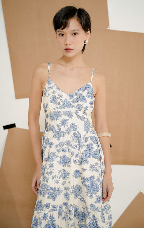 Model mengenakan Agariste Floral Whisper Maxi Dress Blue, long dress wanita tanpa lengan dengan motif floral bunga biru yang elegan untuk tampilan feminin.