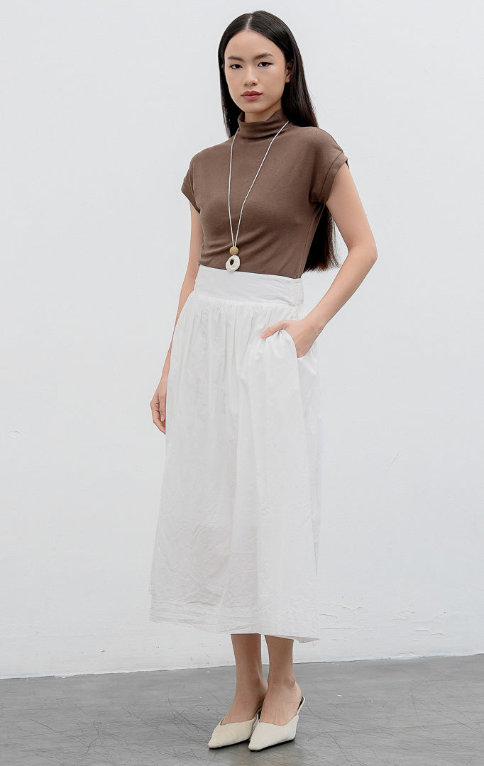 Rok panjang wanita model mekar (flared skirt) warna putih (white) Alora Skirt berbahan katun berfuring dengan pinggang tinggi (high waist).
