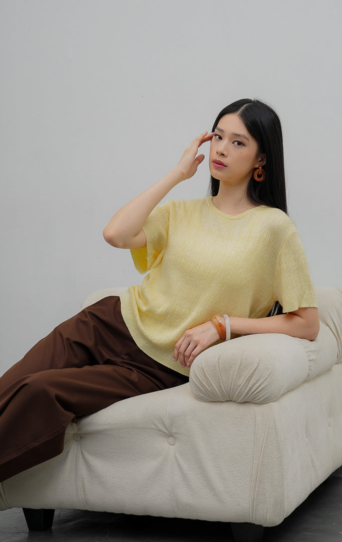 Atasan rajut wanita lengan pendek warna kuning muda (butter yellow) Anatella Top dengan kerah bulat (crew-neck) dan tekstur rajut halus (fine textured knit).