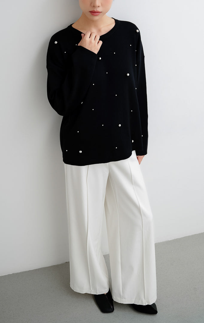 Sweater rajut wanita warna hitam Ardena Sweater dengan aksen hiasan metal studs, kerah bulat (round neckline), lengan panjang, dan potong relaxed fit.