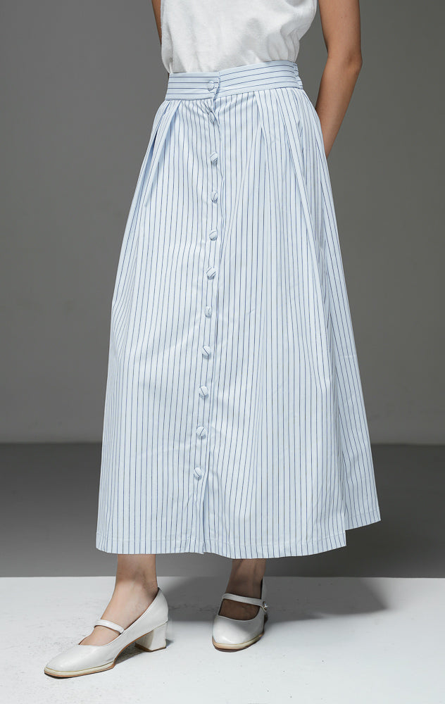 Rok midi wanita Artemis Skirt warna light blue biru muda motif salur garis vertikal dengan kancing depan berlaput kain, detail pleat, dan pinggang karet.