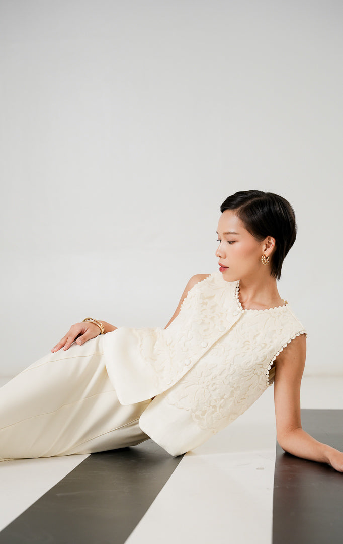 Close up rompi wanita Aster Vest Ivory dengan detail bahan floral jacquard dan kancing depan dari This Is April.
