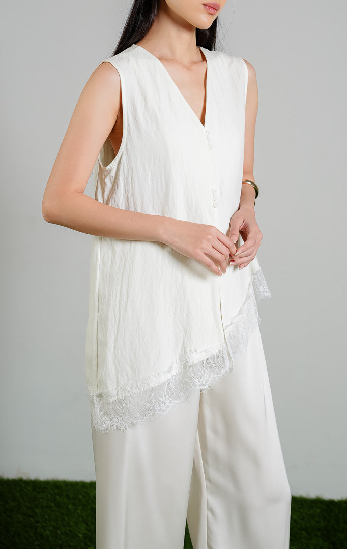 Wynne V-Neck Blouse Top dengan detail Lace Slanted Hem warna ivory, baju atasan tanpa lengan wanita model leher V dan ujung miring berenda warna putih gading dari This Is April.