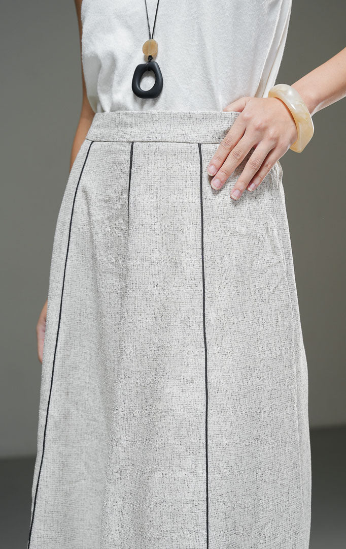 Rok midi wanita Auravie Skirt warna ivory krem bertekstur woven model A-line high waist dengan garis lis piping kontras warna hitam dan lipatan pleat depan.