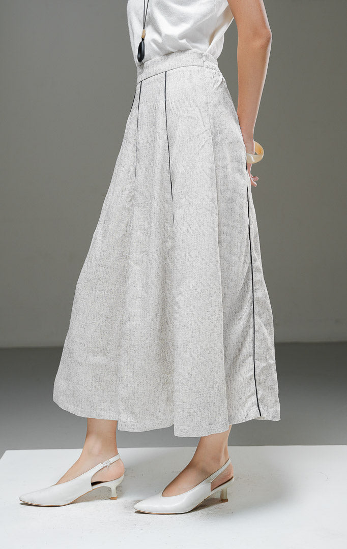 Rok midi wanita Auravie Skirt warna ivory krem bertekstur woven model A-line high waist dengan garis lis piping kontras warna hitam dan lipatan pleat depan.