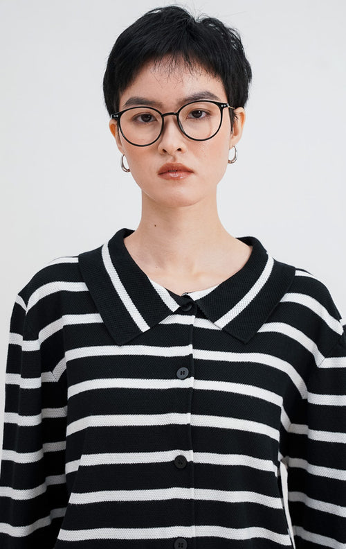 Close up model mengenakan Avrel Cardigan warna black, kardigan rajut ribbed motif garis horizontal putih dengan kerah polo hitam dan kancing depan