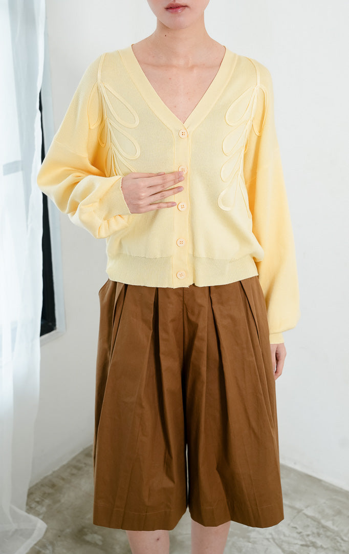 Kardigan rajut wanita lengan panjang warna kuning muda (butter yellow) Bailey Cardigan berbahan stretch knit dengan leher V (V-neckline), bukaan kancing depan, dan aksen bordir motif bunga di dada (floral embroidery).