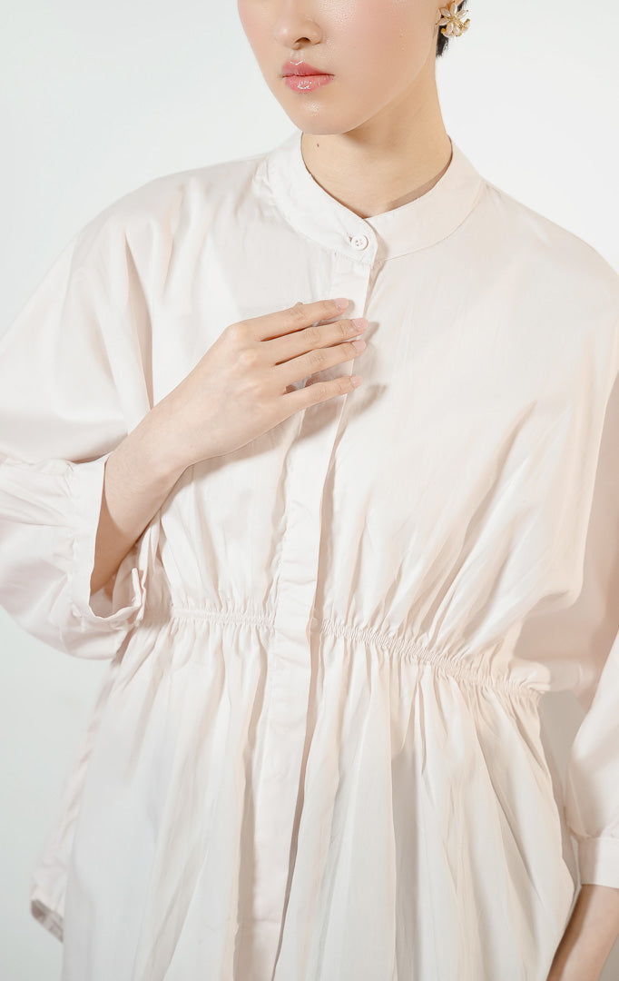 Detail dekat Ginera Ruched Waist Top warna pink, kemeja blouse wanita lengan panjang berwarna merah muda pucat dengan kerah sanghai dan detail kerut serut di pinggang.