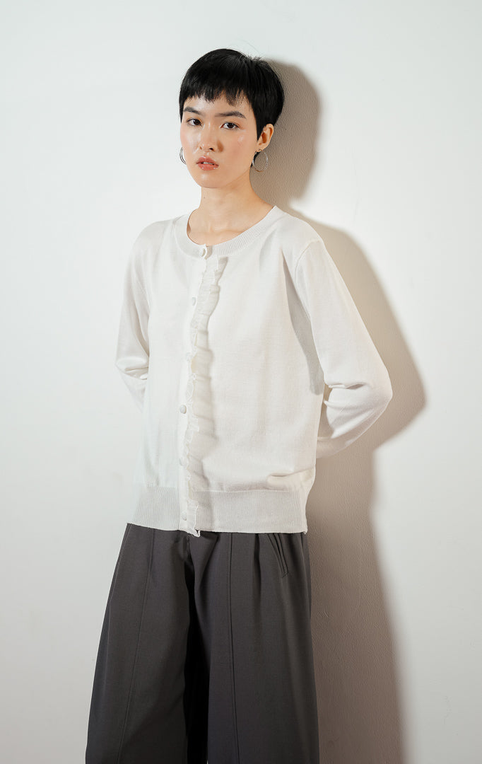 Ruffle Knit Cardigan warna white, outer baju cardigan rajut wanita lengan panjang warna putih dengan detail hiasan rumbai renda manis di bagian kancing.