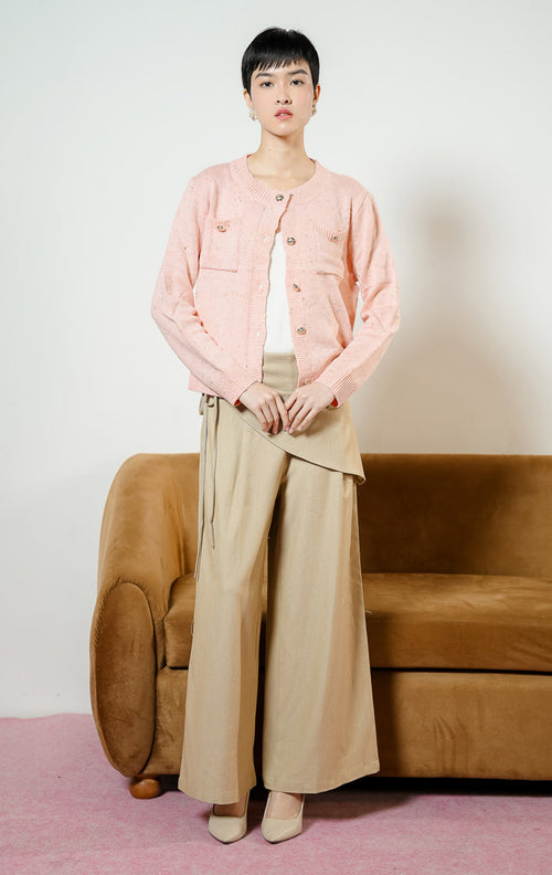 Model wanita mengenakan Chrystelle Gold Button Tweed Knit Cardigan warna pink, luaran kemeja cardigan rajut wanita bertekstur tweed warna merah muda dengan kancing emas mewah dan dua saku depan.
