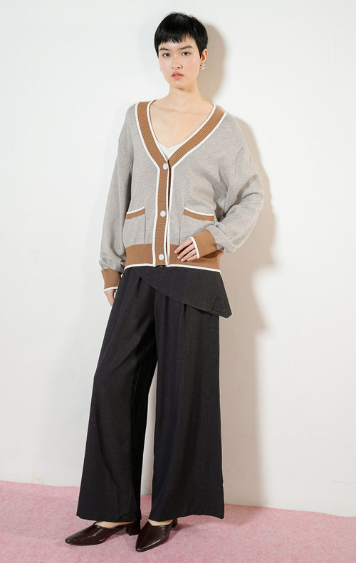 Model wanita mengenakan Montclair V-Neck Contrast Rib Knit Cardigan warna grey, baju outer cardigan rajut wanita leher V warna abu-abu muda dengan detail karet rib kontras warna cokelat ala preppy varsity.