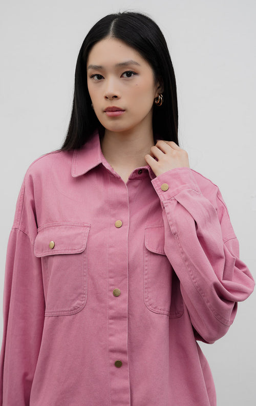 Jaket denim wanita potongan oversized warna merah muda (pink) Carmen Jacket berbahan denim dengan detail kancing jepret warna emas antik (rustic gold snap buttons) dan saku dada fungsional.