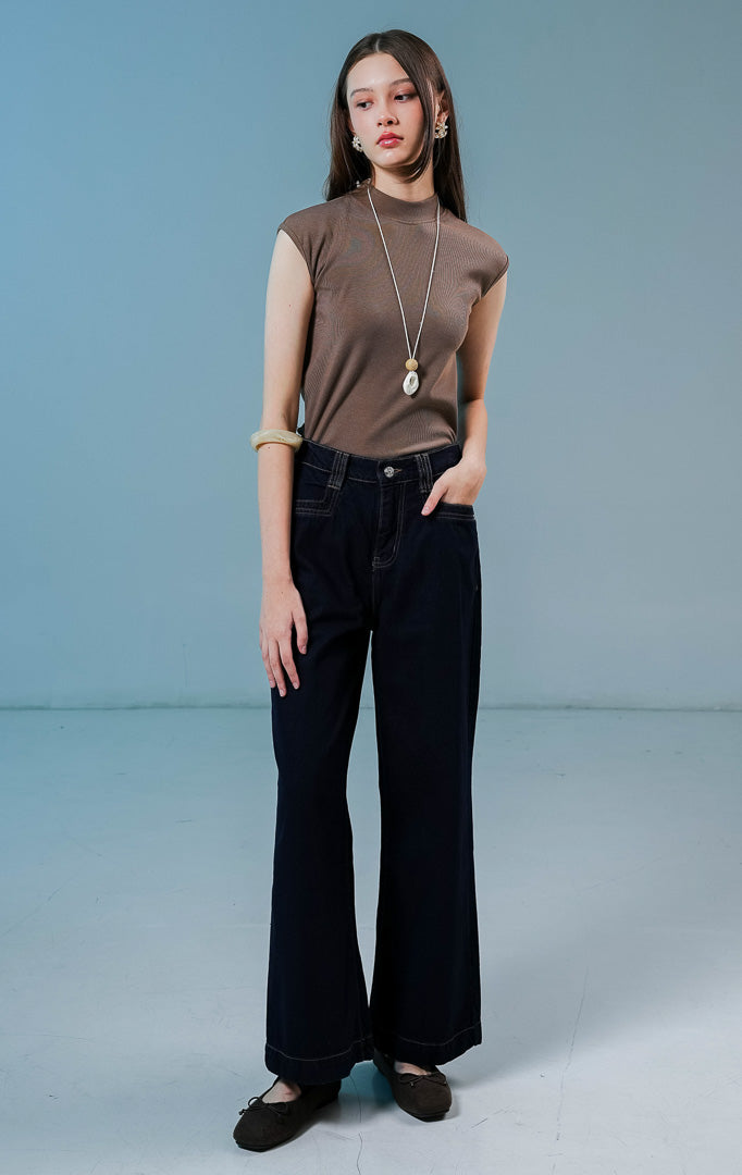 Model wanita mengenakan celana jeans Anaide Straight-Leg Pants warna dark denim berpotongan lurus dengan saku dan kancing depan.