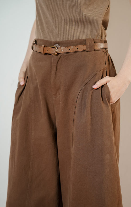 Detail dekat Regina Pants warna dark brown, celana panjang kulot kerja wanita warna cokelat tua dengan potongan pinggang tinggi dan detail jahitan panel melengkung yang unik.