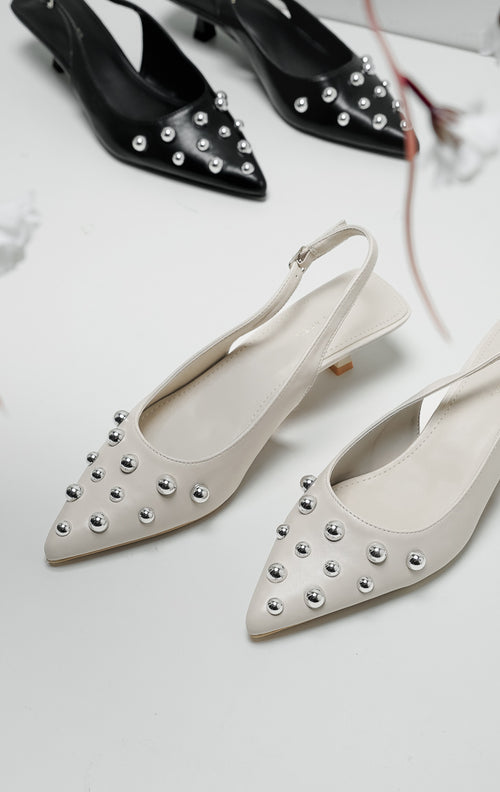 Sepatu heels wanita warna ivory model pointed toe dengan detail hiasan bola perak (silver studs) dan tali slingback.