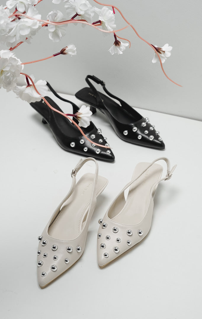 Sepatu heels wanita warna ivory model pointed toe dengan detail hiasan bola perak (silver studs) dan tali slingback.