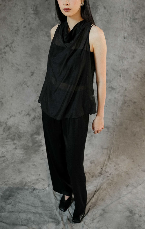 Blouse wanita tanpa lengan Charlette warna hitam polos dengan bahan transparan (sheer) yang elegan, cocok dipadukan dengan inner untuk look semi-formal.