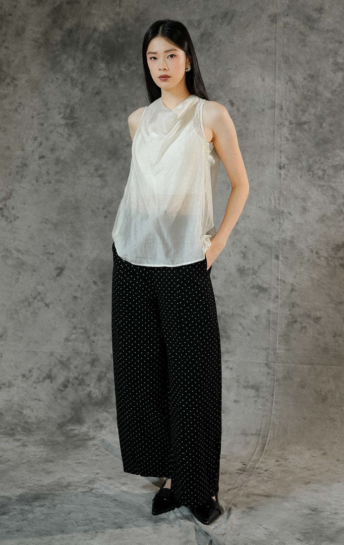 Atasan tanpa lengan wanita Charlette warna ivory dengan material poliester transparan (sheer finish) berdesain rapi dan kancing leher belakang.