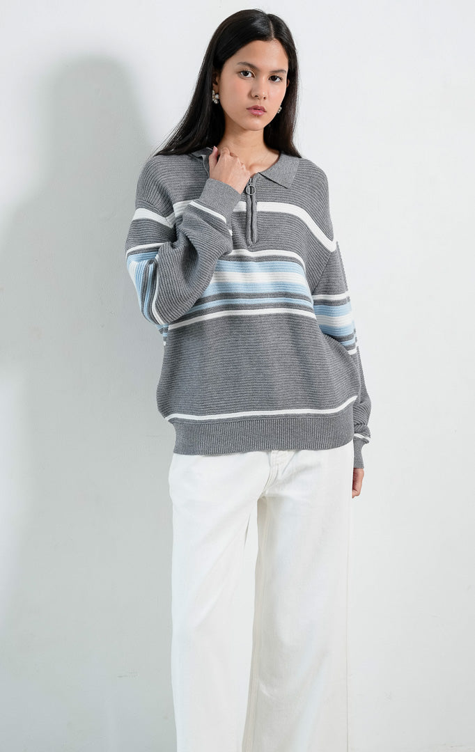 Sweater rajut bertekstur lengan panjang warna abu-abu (grey textured knit pullover) Colleen Sweater dengan kerah, bukaan setengah resleting (half-zip front), serta detail motif garis horizontal warna krem dan biru muda (tonal horizontal stripe detailing).