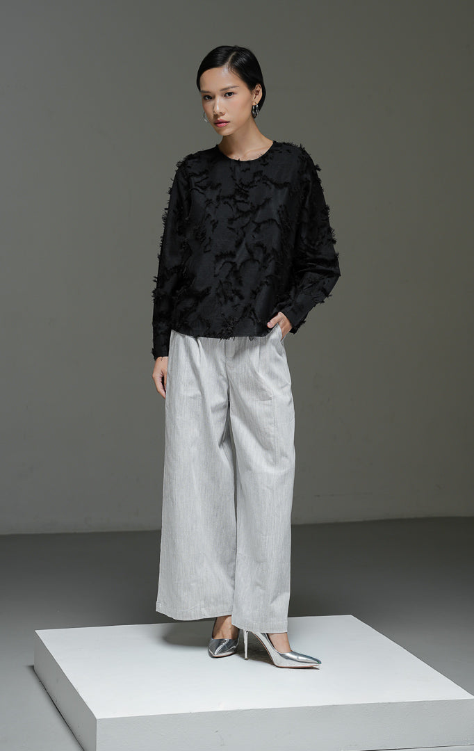 Blouse wanita Demetrius Top warna hitam lengan panjang dengan tekstur bulu halus (fringe jacquard), kerah bulat, dan kancing belakang.