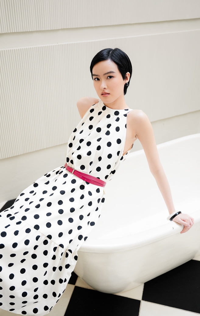 Dress wanita tanpa lengan motif polkadot warna ivory (krem/putih gading) Domino Dress dengan model halter neck, detail gathered, dan furing penuh.