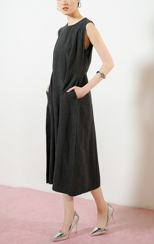 Model wanita mengenakan Abrielle Dress warna black, midi dress tanpa lengan wanita berwarna hitam dengan detail lipit bahu dan saku samping fungsional.