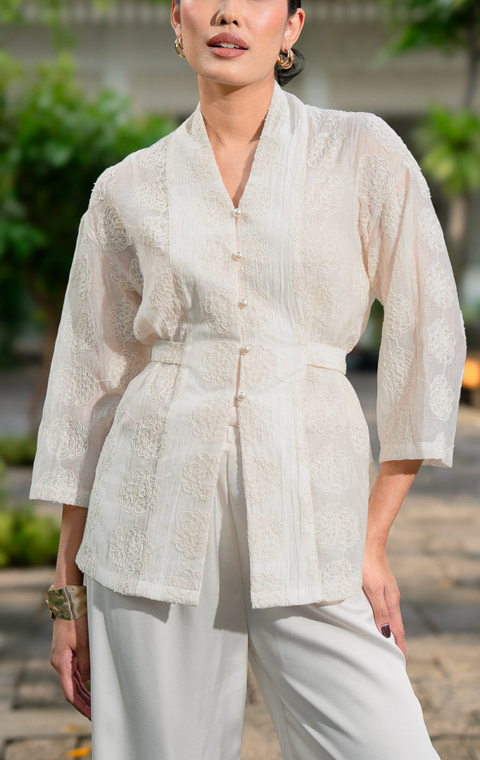 EID Aliyah Top Ivory, atasan wanita model kimono warna putih gading
bahan cotton voile transparan dengan motif bordir bunga timbul dan
kancing depan mutiara.