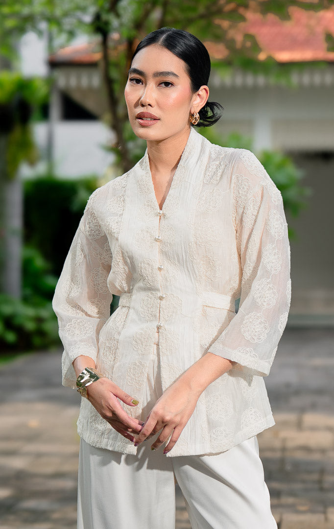 EID Aliyah Top Ivory, atasan wanita model kimono warna putih gading
bahan cotton voile transparan dengan motif bordir bunga timbul dan
kancing depan mutiara.