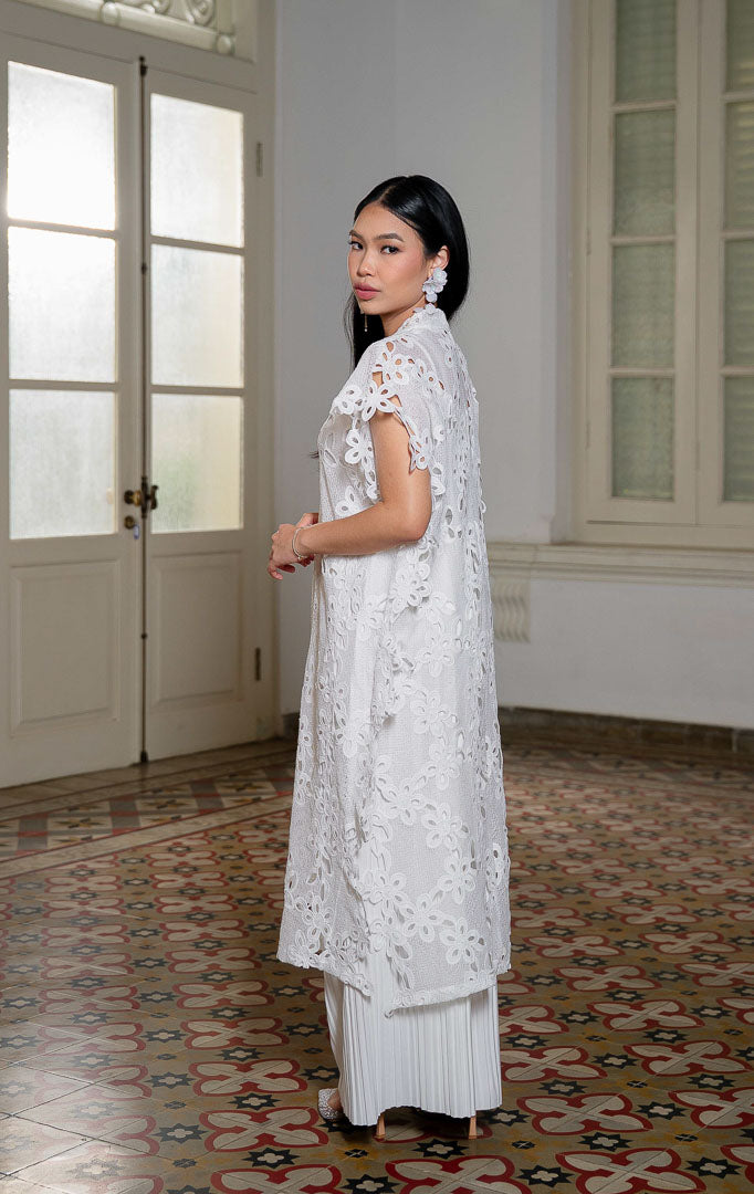 EID Halima Dress White, luaran vest panjang wanita warna putih bahan lace
bordir floral transparan dengan motif kerawang openwork dan detail
pinggiran bergelombang scallop.