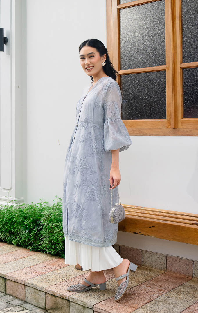 EID Isra Dress Grey, gamis panjang wanita warna abu abu bahan cotton
voile dengan motif bordir bunga penuh, lengan balon, dan kancing depan
mutiara.