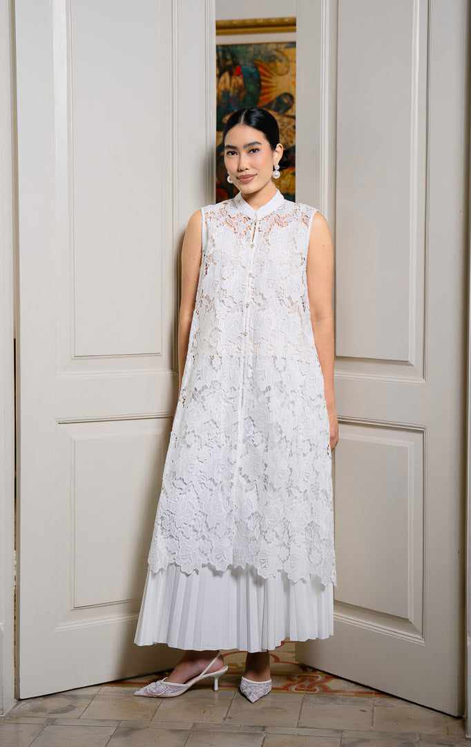 EID Kanira Dress White, luaran rompi panjang wanita bahan lace motif
bunga warna putih bersih dengan kerah shanghai, tanpa lengan, dan
kancing depan.
