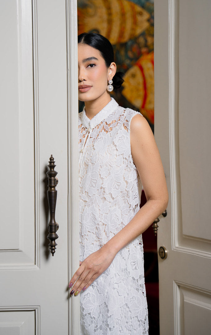 EID Kanira Dress White, luaran rompi panjang wanita bahan lace motif
bunga warna putih bersih dengan kerah shanghai, tanpa lengan, dan
kancing depan.