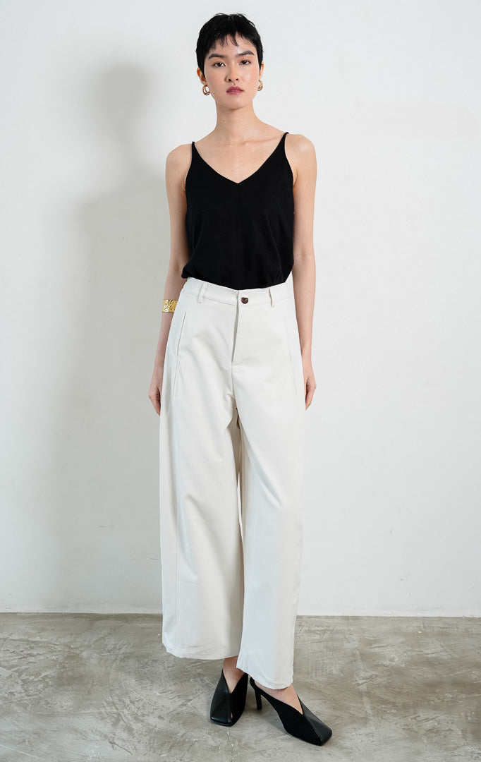 Celana panjang wanita potongan lurus warna putih (white straight-cut long pants) Emmanuel Pants dengan siluet minimalis yang bersih (clean minimal silhouette), ban pinggang berstruktur dengan kancing, dan tampilan serbaguna yang elegan (polished structured shape).