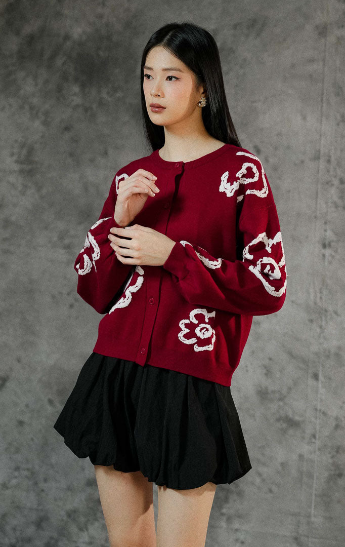 Kardigan rajut wanita Emmelie warna maroon lengan panjang dengan motif bunga (floral), berkerah bulat, kancing depan, dan ujung lengan karet elastis.