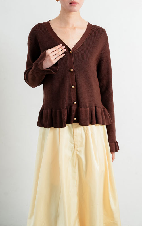 Kardigan rajut wanita lengan panjang warna cokelat tua (dark brown) Eugenia Cardigan berstruktur knit dengan potongan pinggang mekar (peplum silhouette), leher V (V-neckline), dan kancing emas (gold-tone buttons).